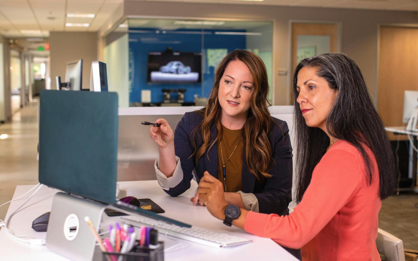 two women sitting at a table looking at a computer screen by LinkedIn Sales Solutions courtesy of Unsplash.