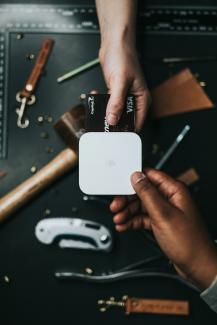 person holding Visa card and white device by Nathan Dumlao courtesy of Unsplash.